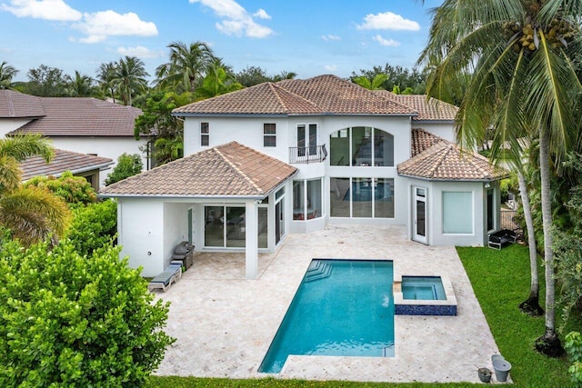 16370 Via Fontana, Delray Beach, FL 33484 - rear view of house featuring a balcony, stucco siding, a patio area, a tiled roof, and a pool with connected hot tub