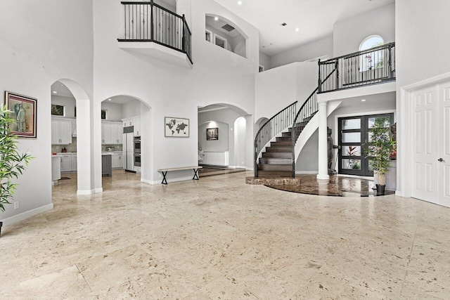 16370 Via Fontana, Delray Beach, FL 33484 - foyer featuring a high ceiling, baseboards, arched walkways, and stairs