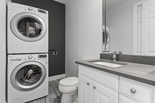 16370 Via Fontana, Delray Beach, FL 33484 - bathroom featuring stacked washer and clothes dryer, vanity, toilet, and baseboards