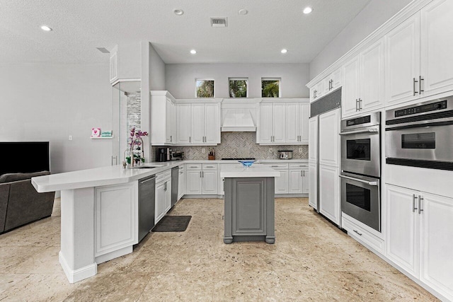 16370 Via Fontana, Delray Beach, FL 33484 - kitchen featuring appliances with stainless steel finishes, a peninsula, light countertops, white cabinets, and recessed lighting