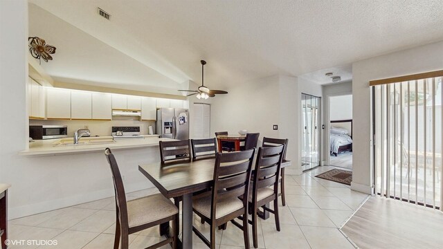 8912 Thumbwood Cir Unit C, Boynton Beach, FL 33436 - dining area featuring ceiling fan, light tile patterned flooring, baseboards, vaulted ceiling, and a textured ceiling