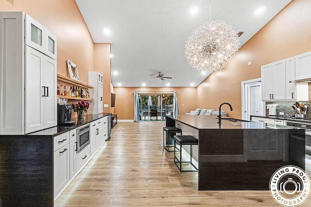 4038 Calamondin Blvd, The Acreage, FL 33470 - kitchen with dark countertops, a sink, a ceiling fan, stainless steel microwave, and high vaulted ceiling