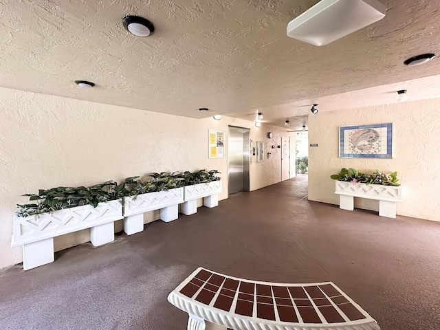 3154 Via Poinciana Unit 409, Lake Worth, FL 33467 - misc room featuring elevator, a textured wall, and a textured ceiling
