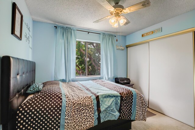 3154 Via Poinciana Unit 409, Lake Worth, FL 33467 - carpeted bedroom with a textured ceiling, a closet, and ceiling fan