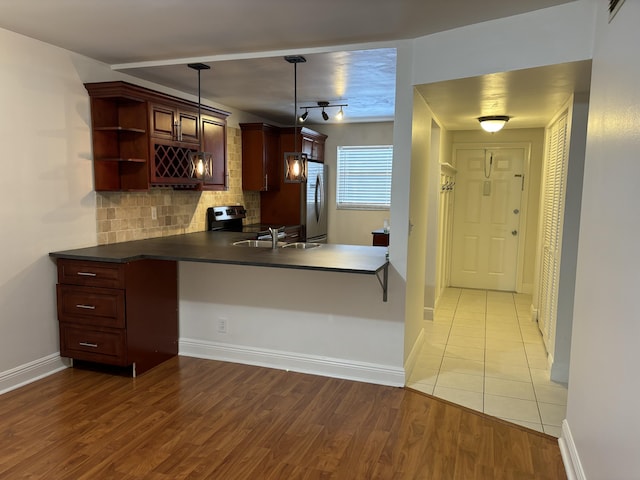 2895 SW 22nd Ave Unit 2060, Delray Beach, FL 33445 - kitchen with appliances with stainless steel finishes, open shelves, dark countertops, backsplash, and wood finished floors
