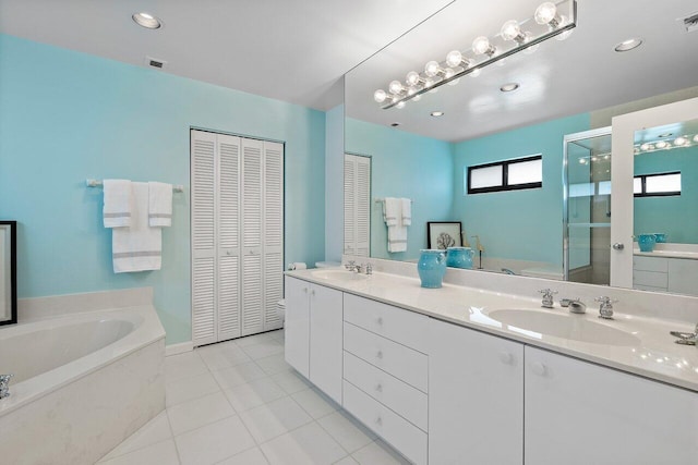 4483 Meadowlark Ln, Boynton Beach, FL 33436 - bathroom featuring a closet, a garden tub, double vanity, a shower stall, and tile patterned flooring
