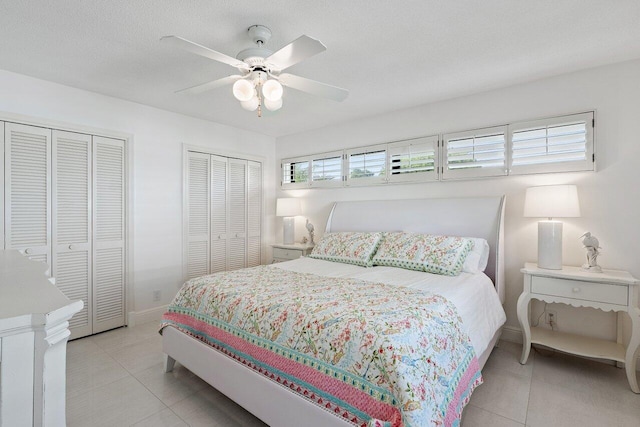 4483 Meadowlark Ln, Boynton Beach, FL 33436 - bedroom with two closets, light tile patterned floors, ceiling fan, and baseboards