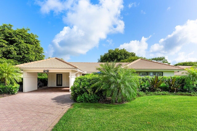 4483 Meadowlark Ln, Boynton Beach, FL 33436 - view of front of property with a tile roof, decorative driveway, a front yard, an attached carport, and stucco siding