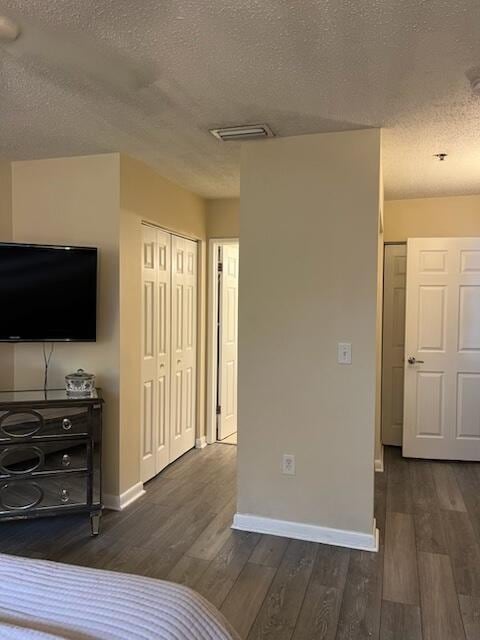 3153 Clint Moore Rd Unit 204, Boca Raton, FL 33496 - bedroom featuring a textured ceiling, baseboards, dark wood finished floors, and a closet