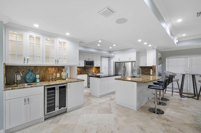 1948 Coco Palm Pl, Lauderdale By The Sea, FL 33062 - kitchen with wine cooler, appliances with stainless steel finishes, a sink, crown molding, and a raised ceiling