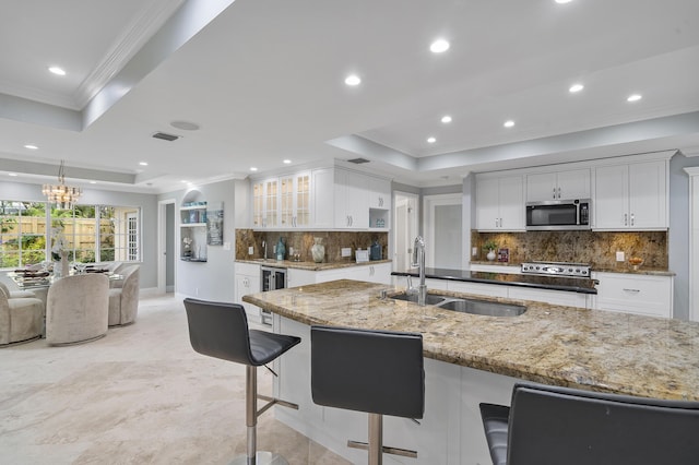 1948 Coco Palm Pl, Lauderdale By The Sea, FL 33062 - kitchen featuring stainless steel microwave, a tray ceiling, a sink, ornamental molding, and beverage cooler
