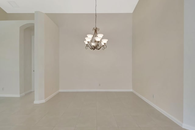 9066 Bay Harbour Cir, West Palm Beach, FL 33411 - spare room featuring arched walkways, baseboards, a chandelier, and light tile patterned floors