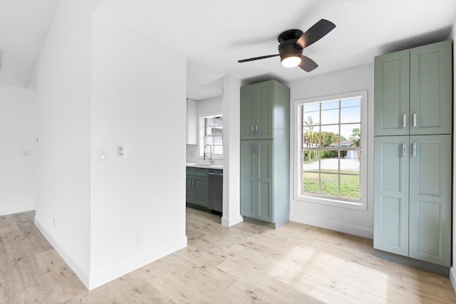 6681 4th St, Jupiter, FL 33458 - unfurnished living room with ceiling fan, baseboards, light wood-style flooring, and a sink