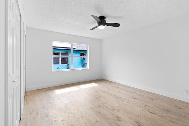 6681 4th St, Jupiter, FL 33458 - unfurnished bedroom with light wood-type flooring, a textured ceiling, baseboards, a ceiling fan, and a closet