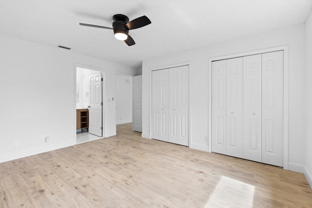6681 4th St, Jupiter, FL 33458 - unfurnished bedroom featuring multiple closets, wood finished floors, baseboards, and ensuite bath