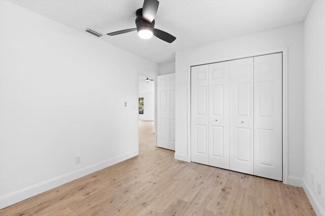 6681 4th St, Jupiter, FL 33458 - unfurnished bedroom featuring light wood finished floors, baseboards, a closet, and a ceiling fan