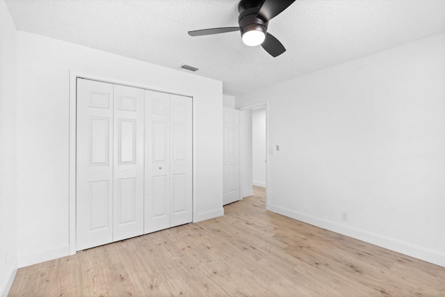 6681 4th St, Jupiter, FL 33458 - unfurnished bedroom with wood finished floors, a textured ceiling, a closet, baseboards, and ceiling fan