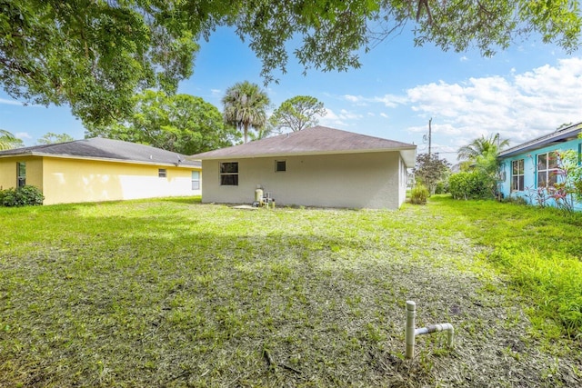 6681 4th St, Jupiter, FL 33458 - back of property with a lawn and stucco siding