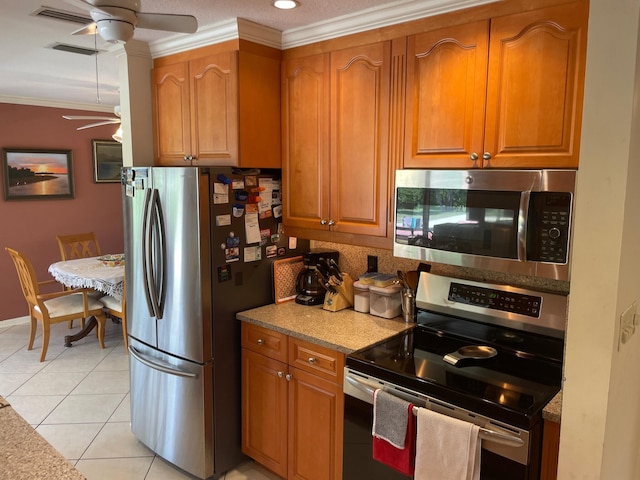 3313 Sherwood Blvd, Delray Beach, FL 33445 - kitchen with appliances with stainless steel finishes, a ceiling fan, ornamental molding, brown cabinets, and light tile patterned floors