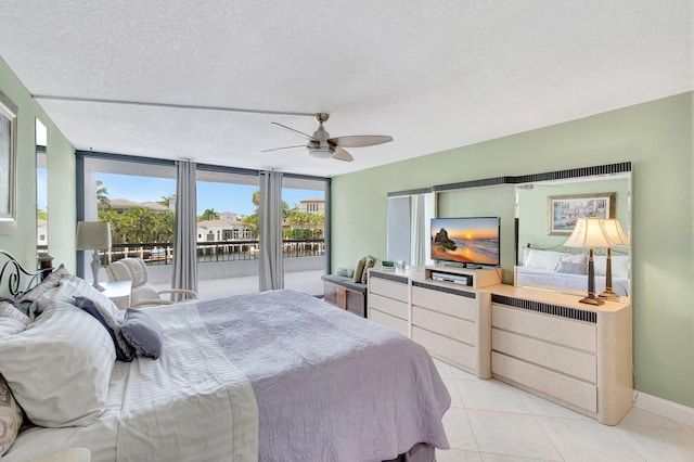 4740 S Ocean Blvd Unit 202, Highland Beach, FL 33487 - bedroom featuring access to outside, light tile patterned flooring, a ceiling fan, baseboards, and a textured ceiling