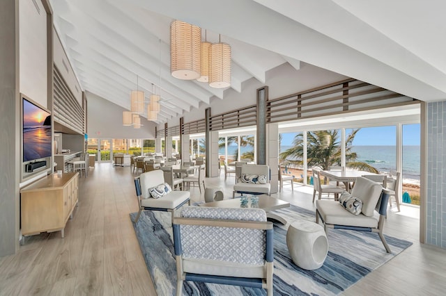 4740 S Ocean Blvd Unit 202, Highland Beach, FL 33487 - living room featuring beamed ceiling, healthy amount of natural light, a water view, light wood-type flooring, and high vaulted ceiling