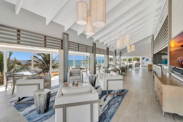 4740 S Ocean Blvd Unit 202, Highland Beach, FL 33487 - living area featuring high vaulted ceiling, beamed ceiling, light wood finished floors, and a water view