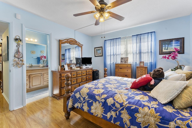 2161 NE 1st Ct Unit 101, Boynton Beach, FL 33435 - bedroom with light wood-style flooring, a ceiling fan, and ensuite bath