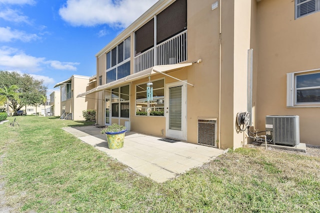 2161 NE 1st Ct Unit 101, Boynton Beach, FL 33435 - back of property featuring cooling unit, stucco siding, a lawn, and a patio area