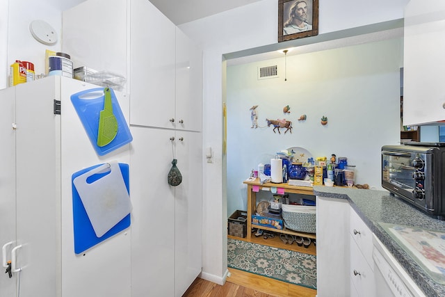 2161 NE 1st Ct Unit 101, Boynton Beach, FL 33435 - kitchen with white cabinetry, light wood-style floors, dishwasher, and dark countertops