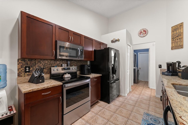 504 SW Pea Ct, Port Saint Lucie, FL 34953 - kitchen with appliances with stainless steel finishes, decorative backsplash, light stone counters, and baseboards