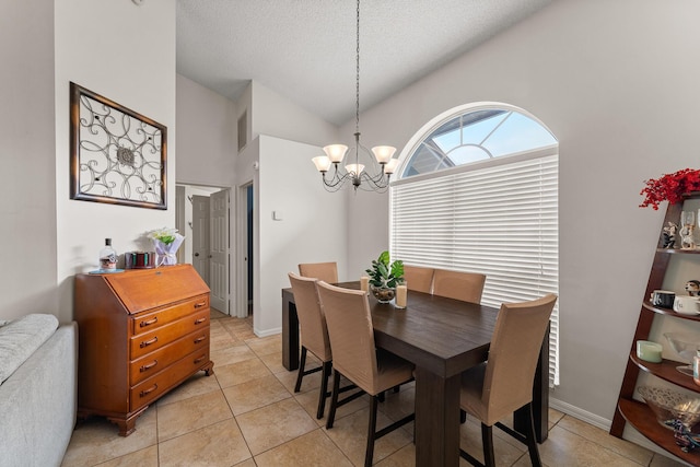 504 SW Pea Ct, Port Saint Lucie, FL 34953 - dining space with a chandelier, a textured ceiling, light tile patterned floors, high vaulted ceiling, and baseboards