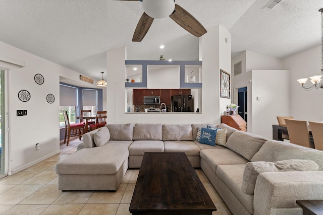 504 SW Pea Ct, Port Saint Lucie, FL 34953 - living area with a textured ceiling, a chandelier, light tile patterned flooring, lofted ceiling, and a ceiling fan