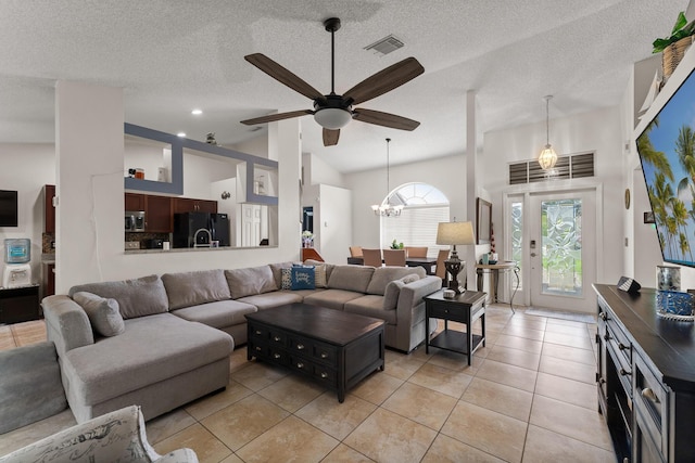 504 SW Pea Ct, Port Saint Lucie, FL 34953 - living room with a ceiling fan, light tile patterned floors, a chandelier, and a textured ceiling