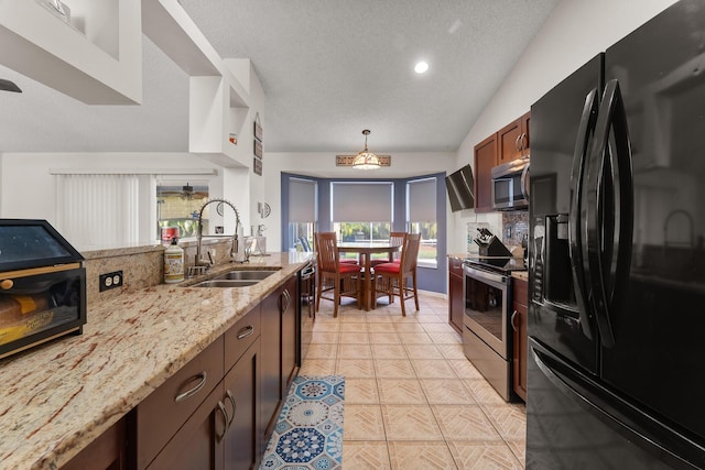 504 SW Pea Ct, Port Saint Lucie, FL 34953 - kitchen with black appliances, a sink, light stone counters, a textured ceiling, and pendant lighting