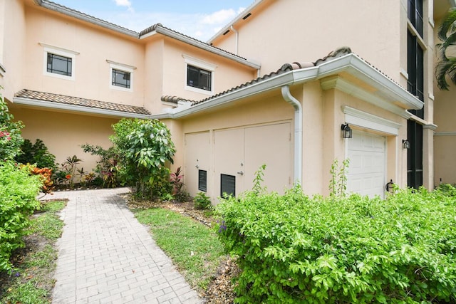 2916 Tuscany Ct Unit 104, Palm Beach Gardens, FL 33410 - view of side of property featuring stucco siding and a tiled roof