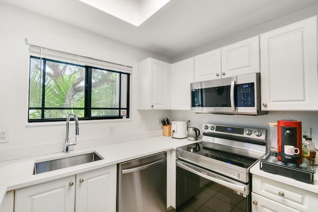2916 Tuscany Ct Unit 104, Palm Beach Gardens, FL 33410 - kitchen with stainless steel appliances, a sink, white cabinetry, and light countertops