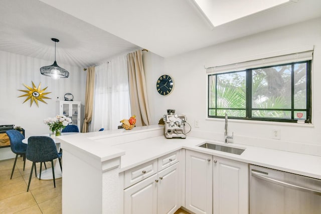 2916 Tuscany Ct Unit 104, Palm Beach Gardens, FL 33410 - kitchen with stainless steel dishwasher, a sink, a peninsula, white cabinetry, and light tile patterned floors