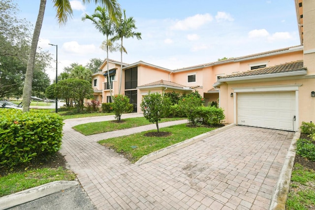 2916 Tuscany Ct Unit 104, Palm Beach Gardens, FL 33410 - townhome / multi-family property featuring an attached garage, stucco siding, and decorative driveway