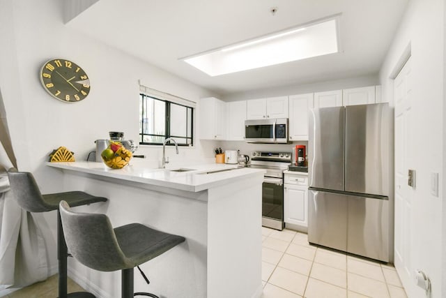 2916 Tuscany Ct Unit 104, Palm Beach Gardens, FL 33410 - kitchen with stainless steel appliances, a sink, a peninsula, and white cabinetry