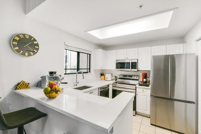 2916 Tuscany Ct Unit 104, Palm Beach Gardens, FL 33410 - kitchen with stainless steel appliances, a sink, a peninsula, and white cabinetry