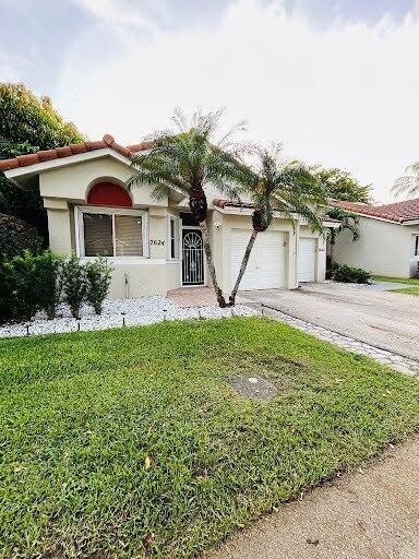 7624 Pinewalk Dr S Unit 147, Margate, FL 33063 - mediterranean / spanish-style home with concrete driveway, a front yard, a garage, and stucco siding