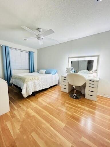 7624 Pinewalk Dr S Unit 147, Margate, FL 33063 - bedroom with light wood finished floors, ceiling fan, and a textured ceiling
