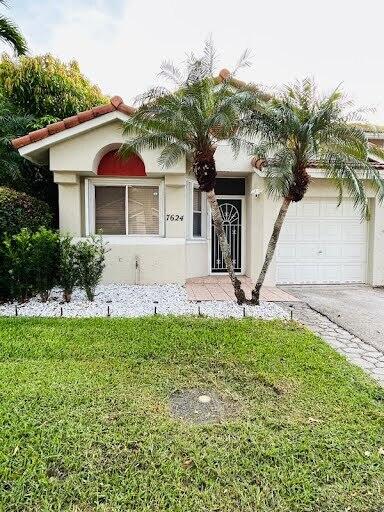 7624 Pinewalk Dr S Unit 147, Margate, FL 33063 - view of front of property featuring a garage, driveway, a front lawn, and stucco siding