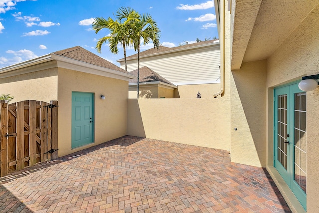 128 W Thatch Palm Cir, Jupiter, FL 33458 - doorway to property with stucco siding, a gate, a patio, and french doors
