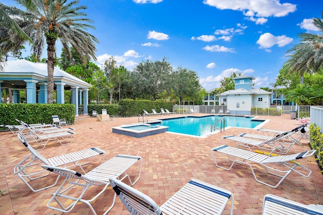 128 W Thatch Palm Cir, Jupiter, FL 33458 - community pool featuring a hot tub and a patio area