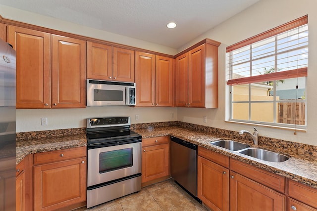 128 W Thatch Palm Cir, Jupiter, FL 33458 - kitchen with stainless steel appliances, a sink, brown cabinets, light tile patterned floors, and recessed lighting