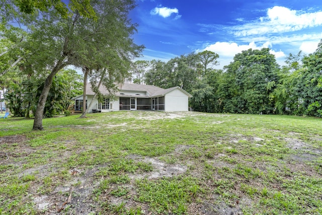 17069 81st Ln N, Loxahatchee, FL 33470 - view of grassy yard with a sunroom and an attached garage