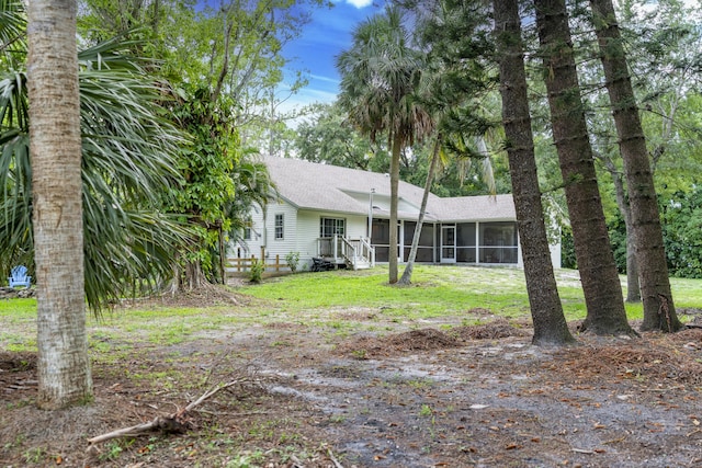 17069 81st Ln N, Loxahatchee, FL 33470 - view of front of property with a sunroom, roof with shingles, and a front yard