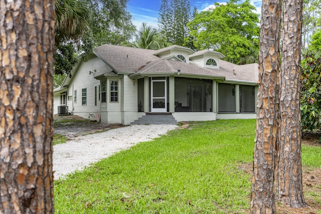 17069 81st Ln N, Loxahatchee, FL 33470 - view of front of property with a front yard, roof with shingles, a sunroom, and central AC unit
