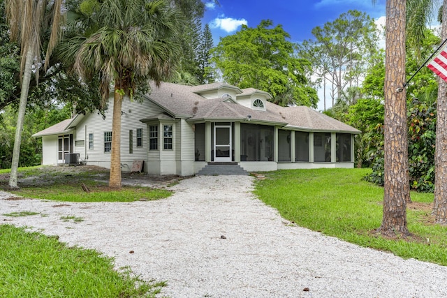 17069 81st Ln N, Loxahatchee, FL 33470 - bungalow-style home with a sunroom, gravel driveway, a shingled roof, and a front lawn